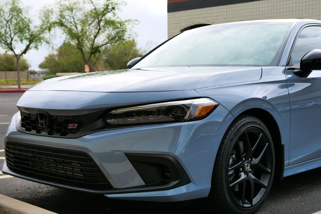 Clean and glossy blue Honda Civic Si parked outside, showcasing how paint protection film helps maintain a vehicle’s pristine appearance over time.