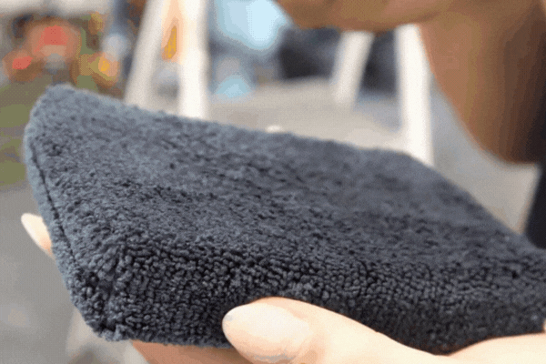 Close-up of a ceramic coating applicator pad held by a technician in Surprise, AZ, used by 48 Detailing to demonstrate what is ceramic coating and how it's applied to protect a car’s surface.