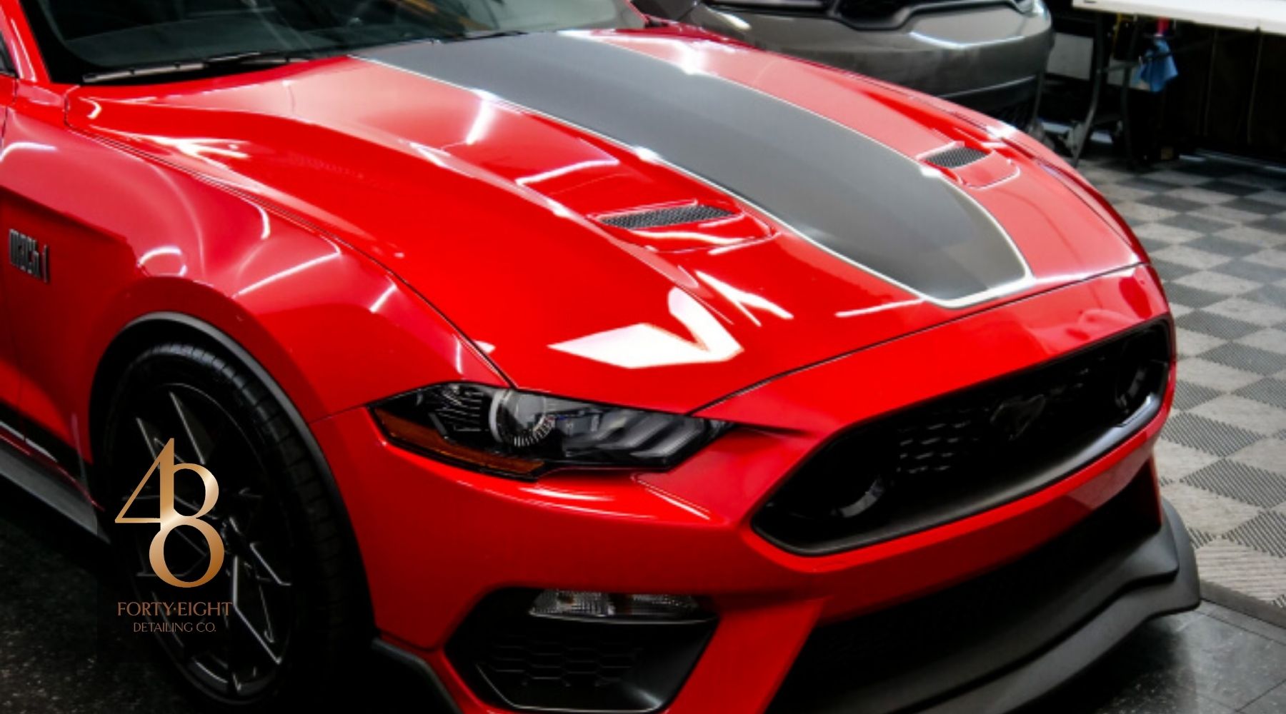Red Ford Mustang with glossy ceramic-coated paint finish inside 48 Detailing’s shop in Surprise, AZ.