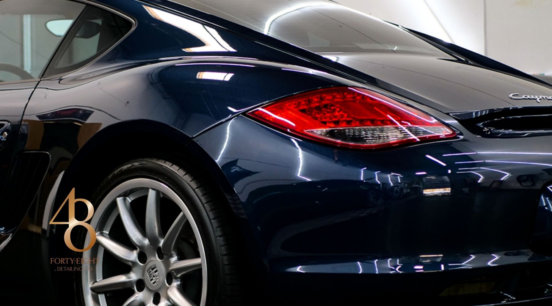 Dark blue sports car with a glossy ceramic-coated finish inside the 48 Detailing studio.